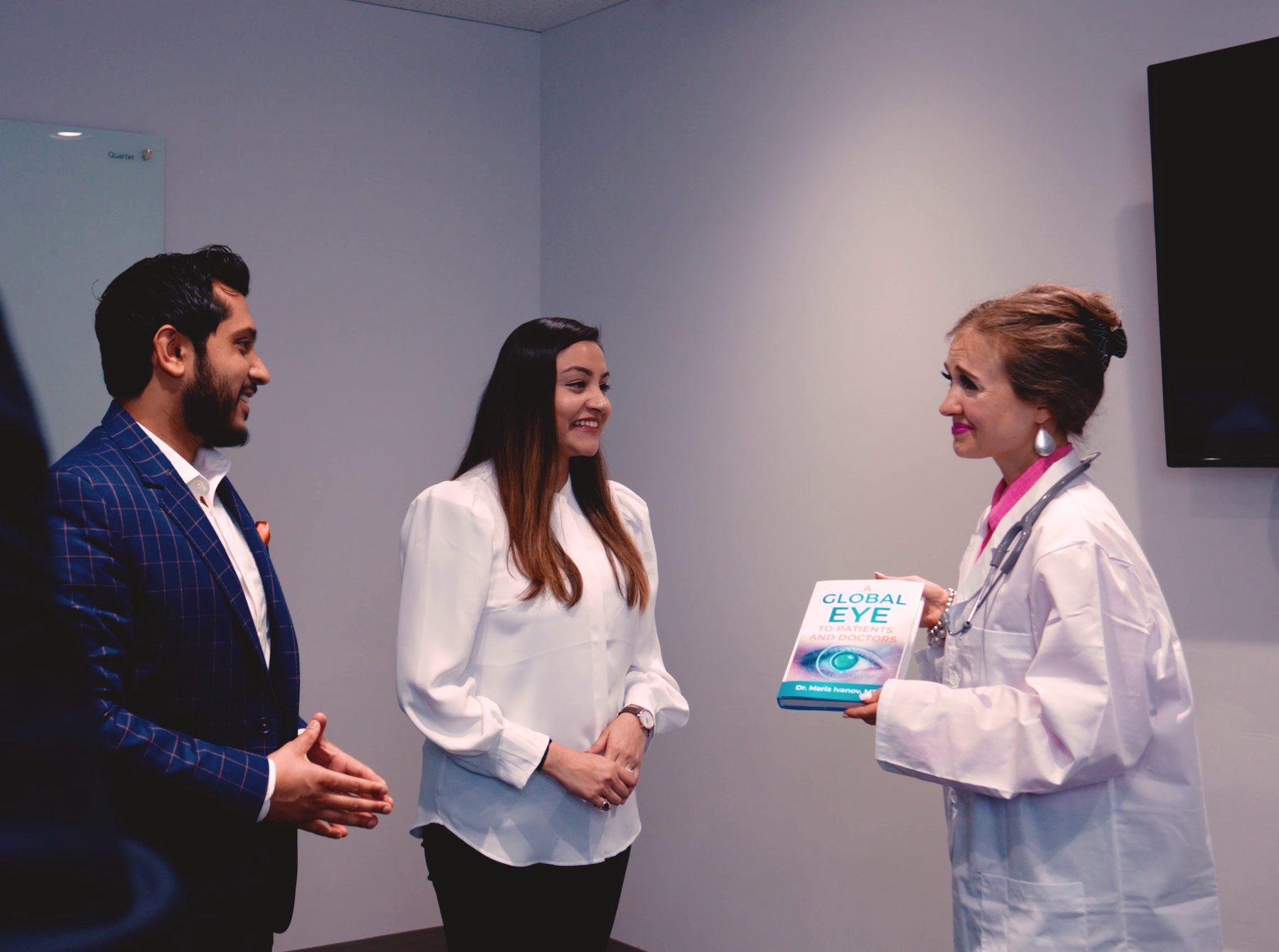 Shri and Dr. Kesha present Dr. Maria Ivanov with her published book, A Global Eye to Patients and Doctors